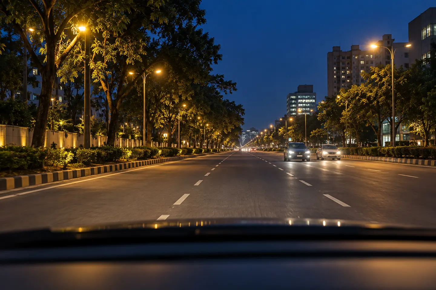 Clear night road with streetlights and oncoming headlights